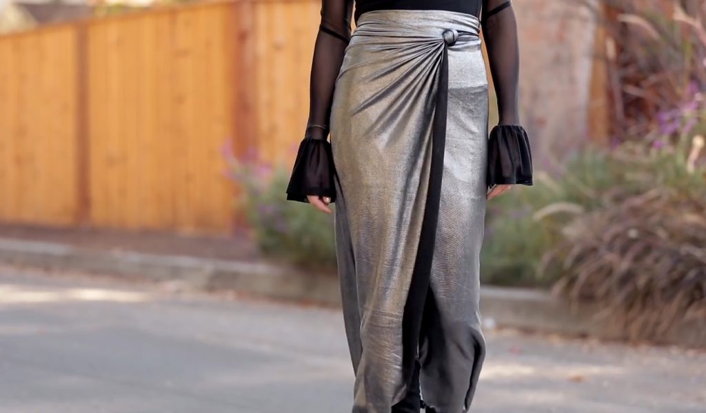 Wrap skirt with overlapping panels and tie-waist detail displayed on a mannequin, showing fabric texture and adjustable fit.